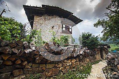 Traditional Bhutanese farmhouse , with firewood on the fence wall , Ura Valley , Bhutan Stock Photo