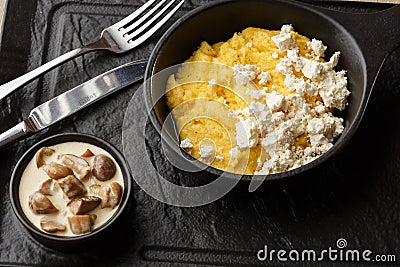 Typical Ukrainian dish polenta - Banosh with cheese and lard. Ukrainian cuisine. maize porridge with bacon, cracklings Stock Photo