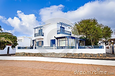 Typical white and blue houses in Playa Honda town near beach on Lanzarote island, Spain. Beautiful vacation home and Stock Photo