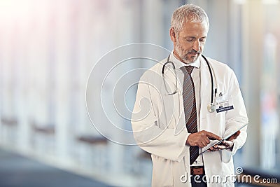 Typing, communication and a doctor with a tablet for healthcare, consulting and cardiology. Hospital, consultant and a Stock Photo