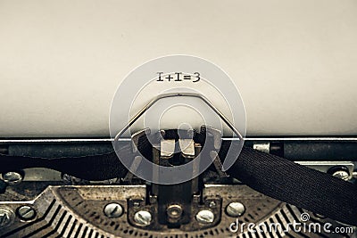 Typing numerals 1 plus 1 equally 3 on a vintage typewriter close-up. concept of teamwork Stock Photo