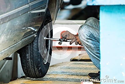 Tyre repairman adjusting the screws of a a wheel on a car in Galle, Sri Lanka Stock Photo