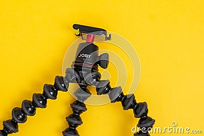 Tyumen, Russia-June 21, 2021: Flexible tripod Joby. Equipment for recording movies on a yellow background. Editorial Stock Photo