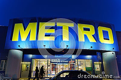 Tyumen, Russia-March 18, 2024: Metro sign stands prominently against the backdrop of a bustling city skyline. Editorial Stock Photo
