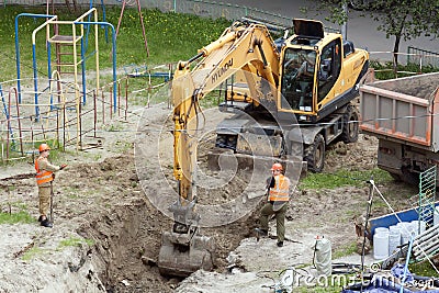 Tyumen, Russia, May 25, 2000: Repair works in the yard of a residential building. The excavator is digging a trench to lay water Editorial Stock Photo