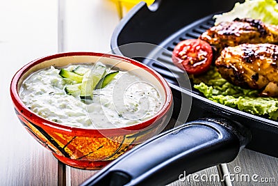 Tzatziki sauce. Tzatziki dressing. Tzatziki dressing with grilled chicken legs and fresh vegetable,lettuce leaf and cherry Stock Photo