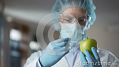 Técnico de laboratorio que inyecta manzanas con las sustancias químicas, añadiendo el olor y la jugosidad almacen de metraje de vídeo Técnico de laboratorio que inyecta manzanas con las sustancias químicas, añadiendo el olor y la jugosidad almacen de metraje de vídeo