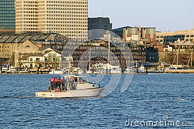 U.S. Coastguard ship patrols Boston Harbor and the Boston skyline from terrorists at sunrise as seen from South Boston Editorial Stock Photo