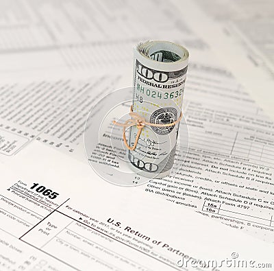 1065 U.S. Return of Parentship Income form with roll of american dollar banknotes Editorial Stock Photo