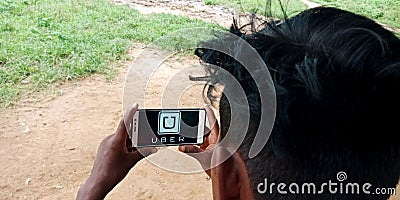 Uber cabs logo on mobile phone screen at village area Editorial Stock Photo