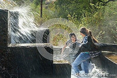 Indian girls swimming in artificial waterfall near Udaipur. India Editorial Stock Photo