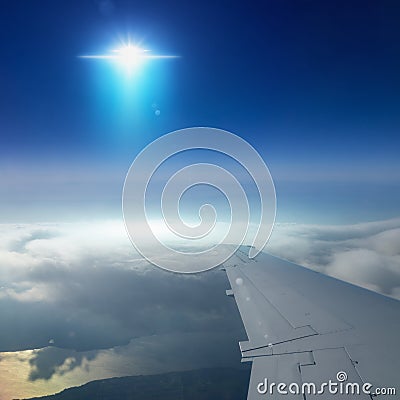 Ufo with bright blue spotlight flies near airplane in dark blue Stock Photo