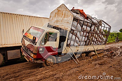 Accident scene of a large semi trucks stuck in the muddy, rutted, unpaved road Editorial Stock Photo