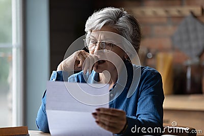 Stressed older latin woman get bad surprise reading official letter Stock Photo