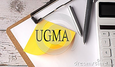 UGMA - Uniform Gifts to Minors Act word on a yellow sticky with calculator, pen and clipboard Stock Photo