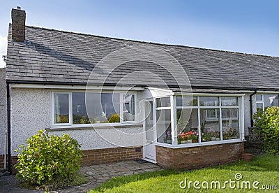 UK 60`s bungalow with slate roof, white quartz render and upvc double glazed windows and front porch Editorial Stock Photo