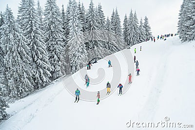 Ukraine, Bukovel - December 15, 2018. Mountain ski spot. Lots of snowboarders and skiers ride from snow hill. Winter Carpathians Editorial Stock Photo