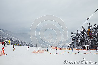 Ukraine. Bukovel - 02 FEBRUARY 2021. Skiers and curbs on the descent from the mountain and christmas trees. Part of the lift up Editorial Stock Photo