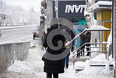 Ukraine Dnipro 27.12.2021 - City dwellers in winter on the street in a sleeping area In the morning they go to the robot, winter Editorial Stock Photo