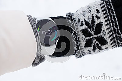 Ukraine Dnipro 26.12.2021 - Smart watch Samsung Galaxy 4.40 mm on a girl`s hand in winter on the street, technology Editorial Stock Photo
