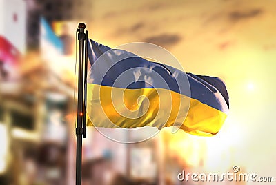 Ukraine Flag Against City Blurred Background At Sunrise Backlight Stock Photo