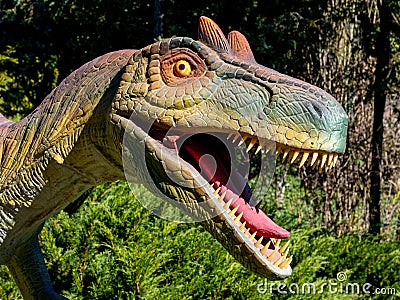 Ukraine, Khmelnitsky, October 2021. Model of a dinosaur, the head of a megaraptor close up in the park in sunny weather Editorial Stock Photo