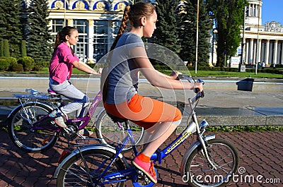 Ukraine, Kiev, May 11, 2015. Two teenage girls ride bicycles. Editorial Stock Photo