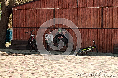 Ukraine, Kremenchug - April, 2019: Children are using a smartphones instead of riding bicycles Editorial Stock Photo