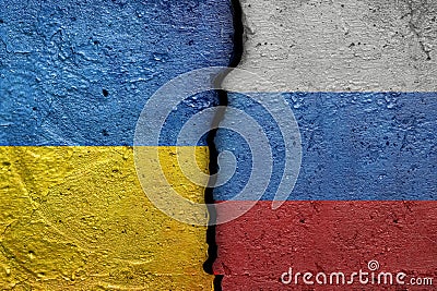 Ukraine and Russia - Cracked concrete wall painted with a Ukrainian flag on the left and a Russian flag on the right stock photo Stock Photo