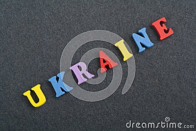Ukraine word on black board background composed from colorful abc alphabet block wooden letters, copy space for ad text Stock Photo