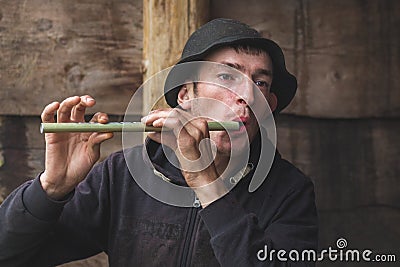 Ukraine, Yaremche. July 2019. Young guy from the mountainous terrain plays on a reed pipe, panpipe. Folk musician_ Editorial Stock Photo