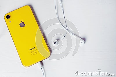 12.08.2019 Ukraine: yellow iphone xr and headphone on isolated background Editorial Stock Photo