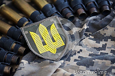Ukrainian army symbol on machine gun belt lies on ukrainian pixeled military camouflage Stock Photo