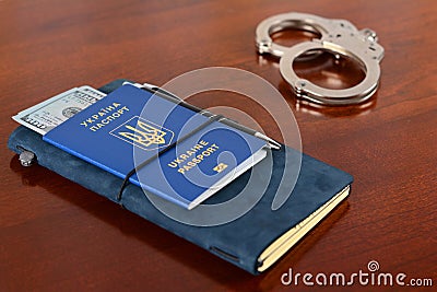 Ukrainian biometric passport and handcuffs on the table.Ukrainian biometric passport. Stock Photo