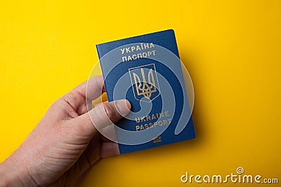 Ukrainian biometric passport id in hand on yellow background Stock Photo