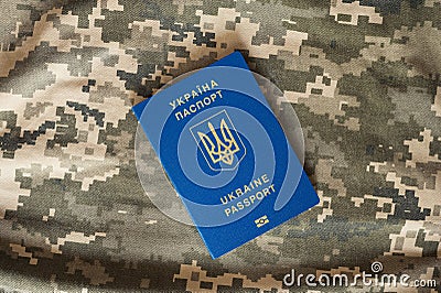 Ukrainian civil foreign passport on military camouflage pixel background. Stock Photo