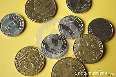 Ukrainian coins isolated on yellow background. Close-up Coins are located in the center of the frame. Conceptual image Stock Photo