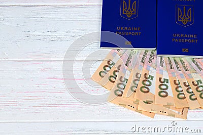 Ukrainian foreign biometric passport with the inscription in Ukrainian - Ukraine passport with hryvnia notes on wooden background Stock Photo