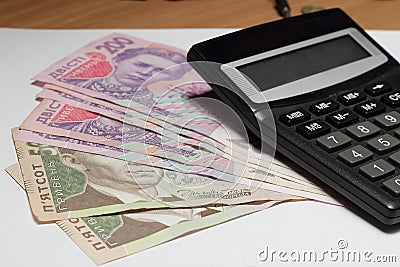 Ukrainian hryvnia and calculator on wooden table Stock Photo