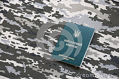 Ukrainian military ID on fabric with texture of pixeled camouflage. Cloth with camo pattern in grey, brown and green pixel shapes Stock Photo