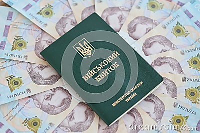 Ukrainian military ID and hryvnia bills. Payments to soldiers of the Ukrainian army, salaries to the military Stock Photo