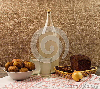 Ukrainian national drink and snack. The big bottle and glass of moonshine on the old wooden table. Russian vodka and snack. Stock Photo