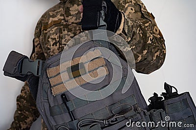 Ukrainian soldier in military pixel unform camouflage with grey bulletproof vest in one arm Stock Photo