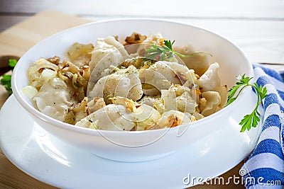 Ukrainian Vareniky or Pierogi stuffed with potato and mushrooms, served with fried onion. Wooden table background Stock Photo