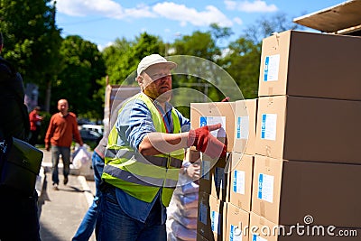 Ukrainian volunteers unloading boxes with humanitarian aid Editorial Stock Photo