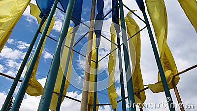 Ukrainische Flaggen, die im Wind gegen einen blauen Himmel flattern Helle gesättigte gelb-blaue Farben stock video footage Ukrainische Flaggen, die im Wind gegen einen blauen Himmel flattern Helle gesättigte gelb-blaue Farben stock video footage