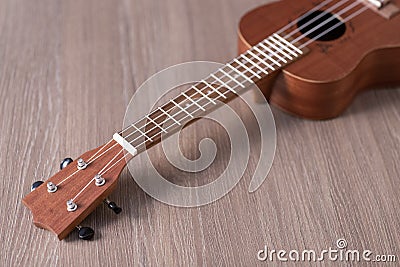 A ukulele lies on a woody background out of focus without people a place to record Stock Photo