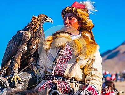 The Golden Eagle Hunter on horseback looking at the well trained eagle Editorial Stock Photo