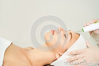 Ultrasonic skin equipment. Woman face cosmetology treatment. Female clinic Stock Photo