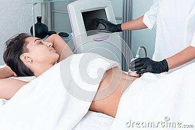 Ultrasound cavitation body contouring treatment. Woman getting anti-cellulite and anti-fat therapy on her leg in beauty Stock Photo